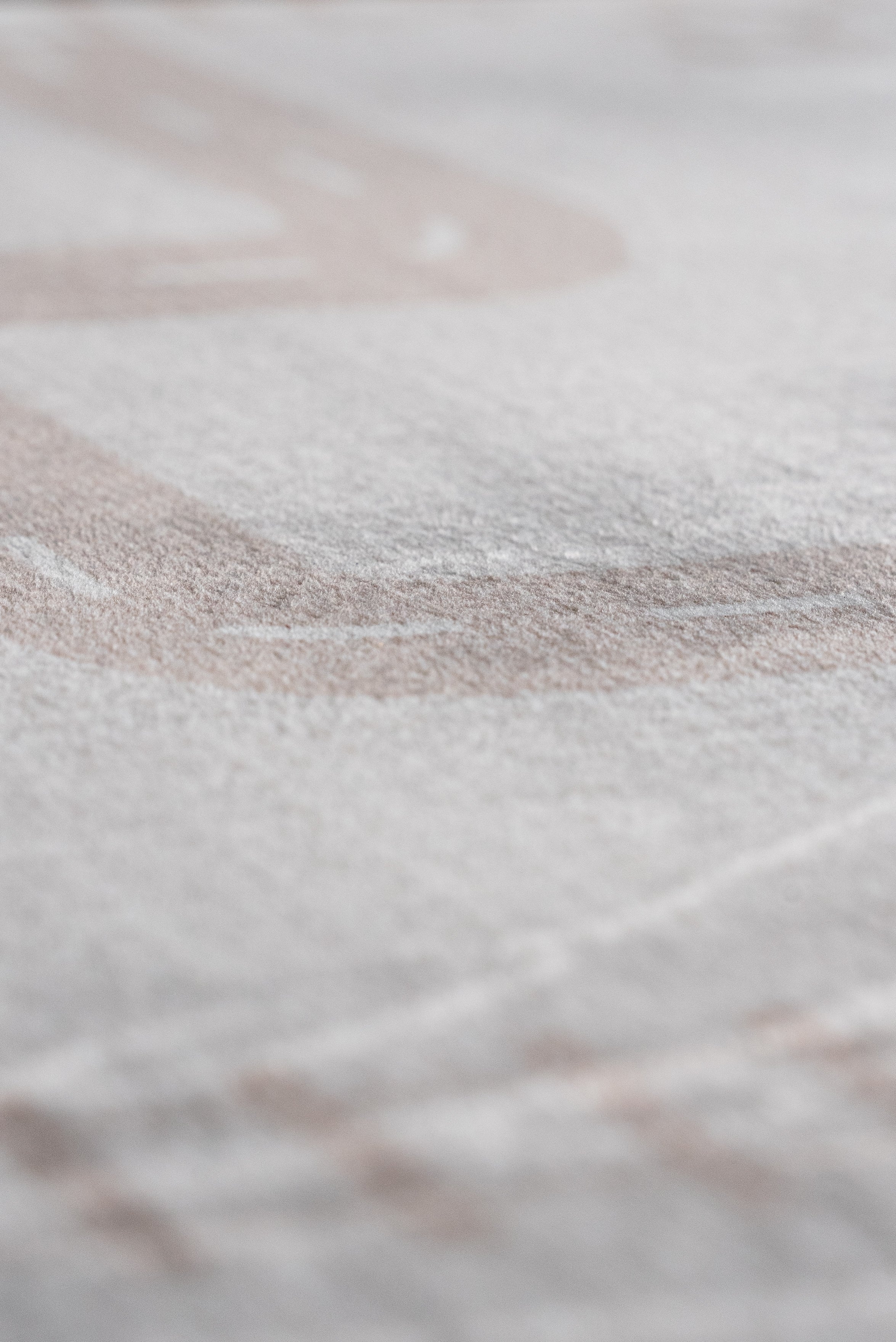 Detailed view of a white sheet with a faint white line, highlighting texture and simplicity.
