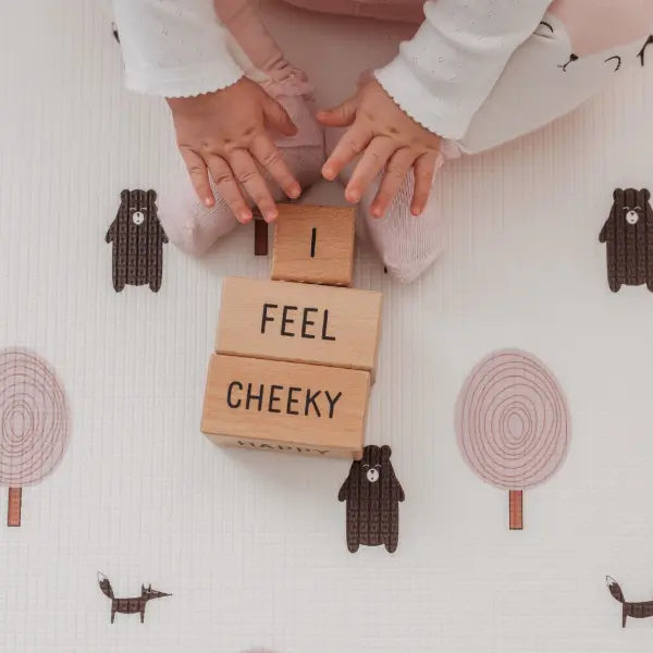 Kid playing on Forrest Blush playmat. Side B has a tree and bear pattern. 