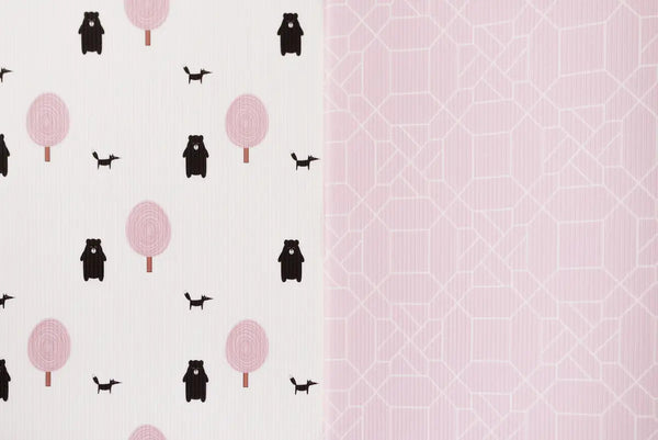 Two sides of Forrest Blush playmat. Side A has a pink geometric pattern and side B has a tree and bear pattern. 