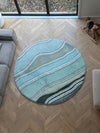 A round rug memory foam tatami with ocean reef artwork placed in a cozy living room setting.