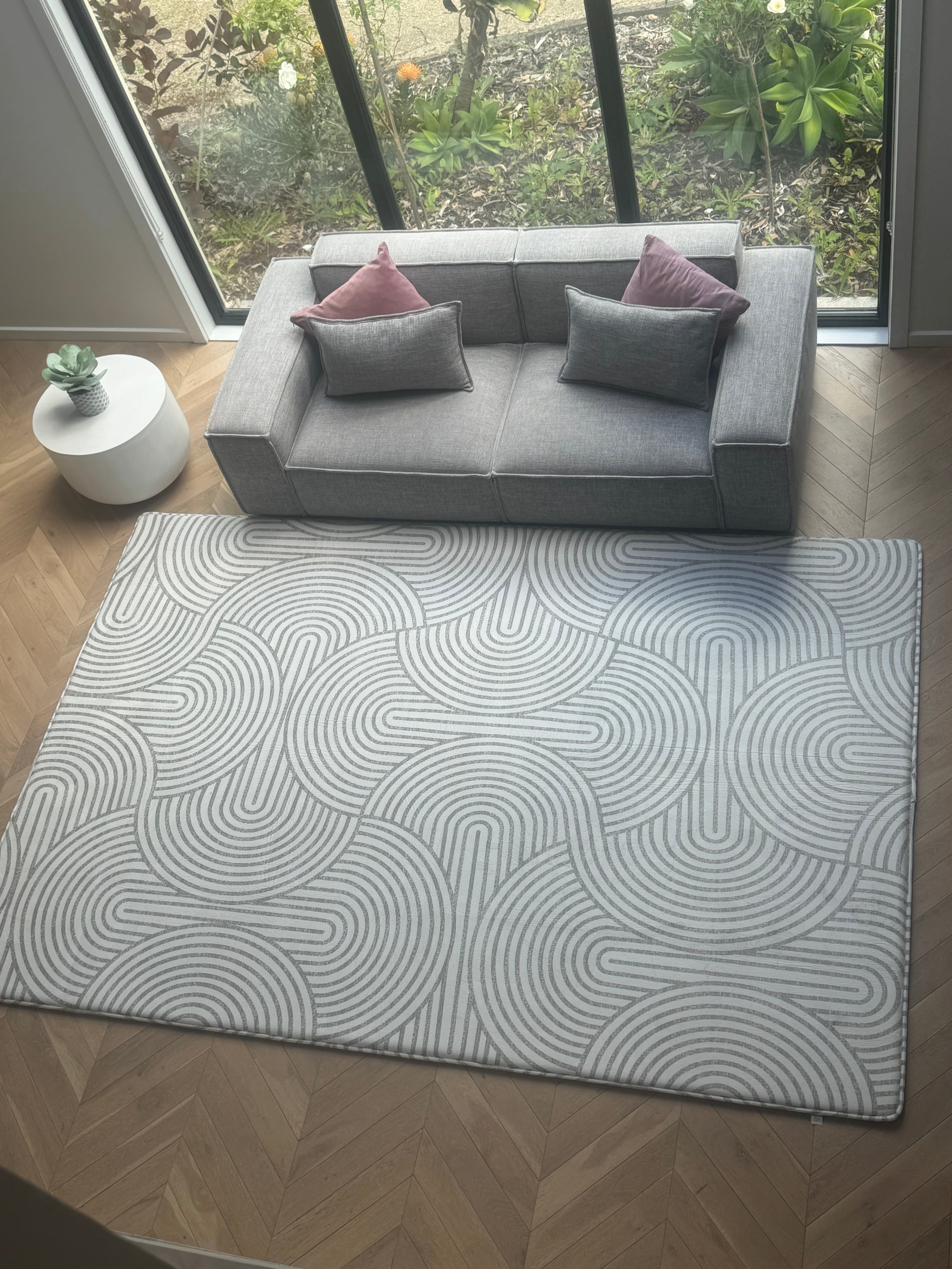  A cozy living room featuring a rug, a couch, and a warm fireplace, creating a welcoming atmosphere.