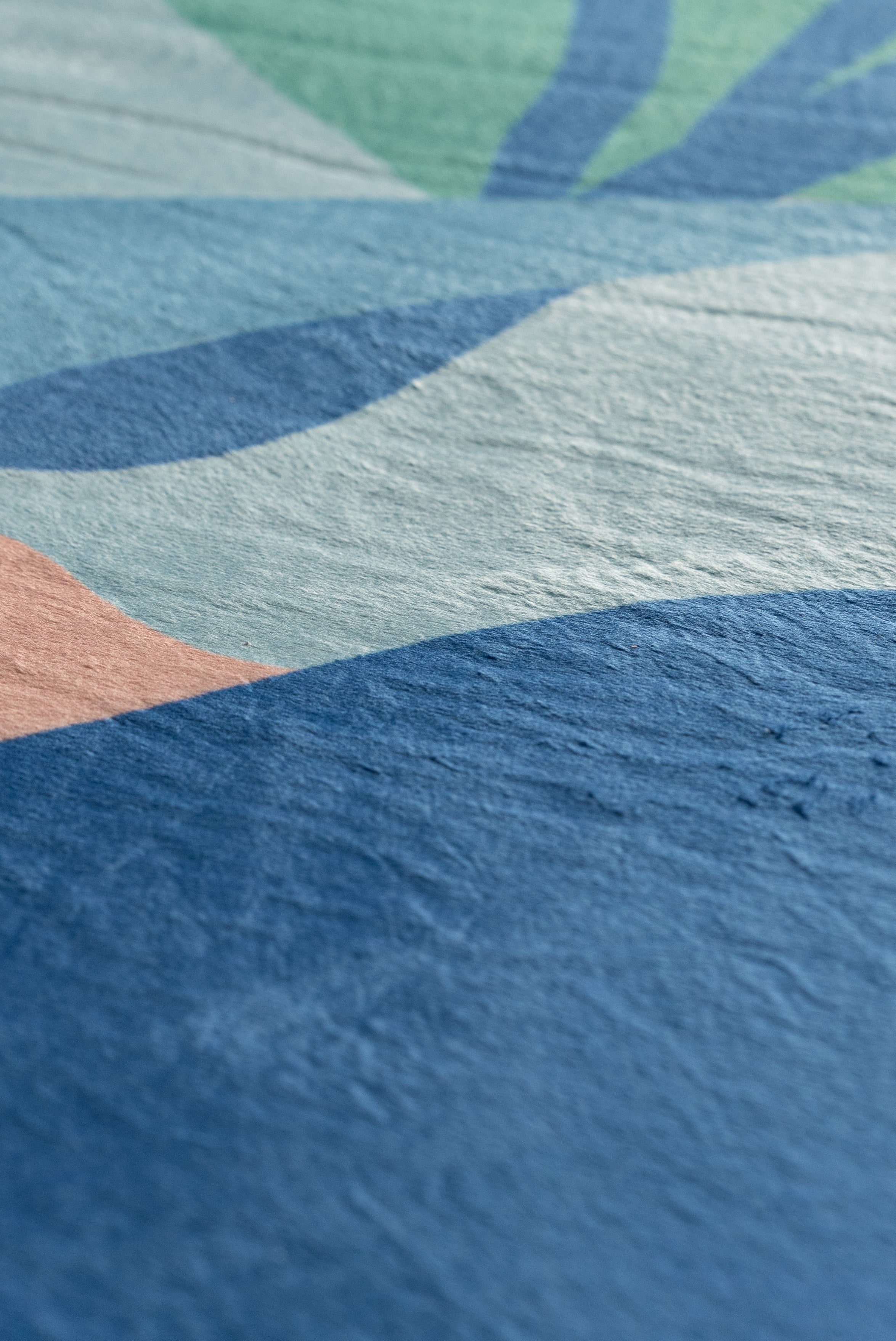 A vibrant rug adorns a living room with a couch and a window, enhancing the space's warmth and style.