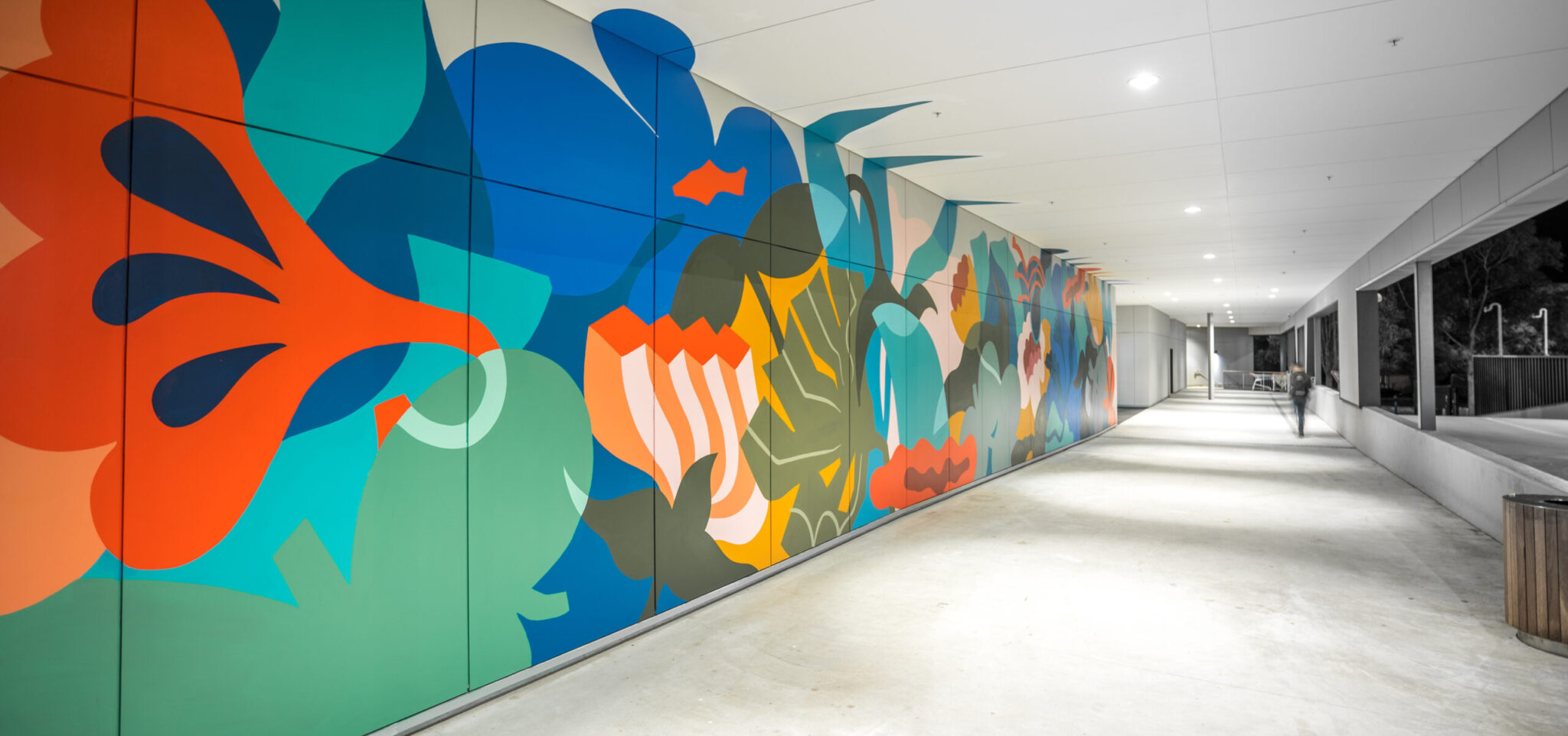 Colorful mural depicting abstract shapes and patterns on a hallway wall, enhancing the space with vibrant art.