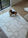 A colorful rug with a toy horse placed on it, situated in a cozy room setting.
